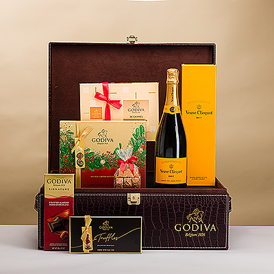 Un magnifique paquet cadeau Godiva avec logo croco comprenant une délicieuse collection de luxueux chocolats Godiva et le célèbre champagne Veuve Clicquot. Cet impressionnant cadeau de champagne et de chocolat est la manière la plus douce de célébrer Noël, le Nouvel An et les grandes réussites professionnelles.